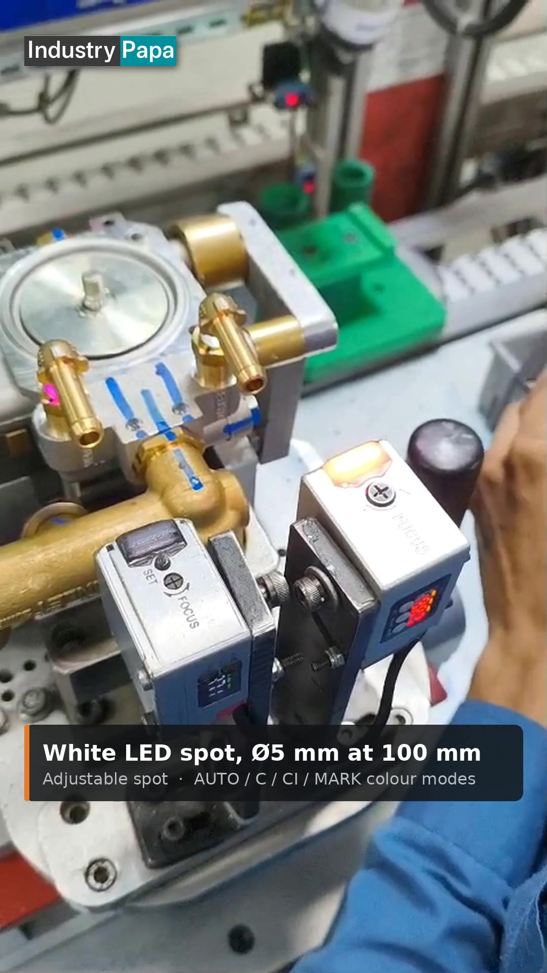 VXT/CM500P-1A colour mark sensor with white LED spot and LED display on a brass valve assembly line